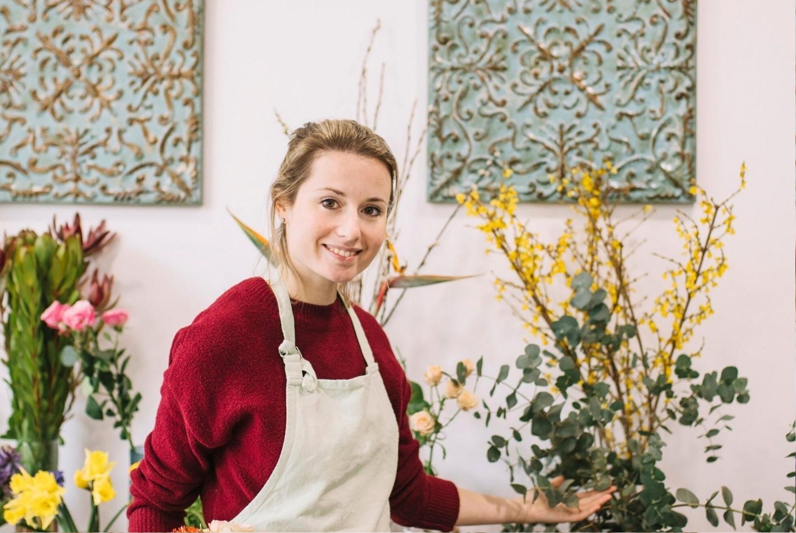 Fortgeschrittenes Blumenarrangement mit strukturierten Schichten aus Leitblumen, Füllmaterial und Gräsern